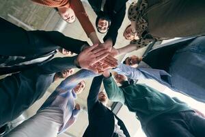 ein Gruppe von Geschäftsleute halten Hände zusammen zu symbolisieren Einheit und Stärke foto