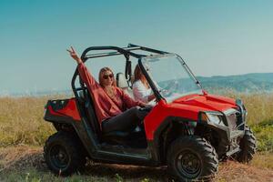 zwei jung glücklich aufgeregt Frauen genießen schön sonnig Tag während Fahren ein aus Straße Buggy Auto auf Berg Natur foto