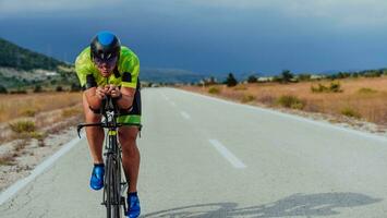 voll Länge Porträt von ein aktiv Triathlet im Sportbekleidung und mit ein schützend Helm Reiten ein Fahrrad. selektiv Fokus foto