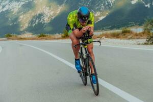 voll Länge Porträt von ein aktiv Triathlet im Sportbekleidung und mit ein schützend Helm Reiten ein Fahrrad. selektiv Fokus foto