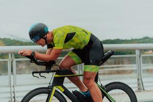 voll Länge Porträt von ein aktiv Triathlet im Sportbekleidung und mit ein schützend Helm Reiten ein Fahrrad. selektiv Fokus foto