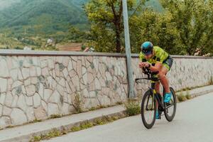 voll Länge Porträt von ein aktiv Triathlet im Sportbekleidung und mit ein schützend Helm Reiten ein Fahrrad. selektiv Fokus foto