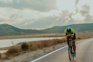 voll Länge Porträt von ein aktiv Triathlet im Sportbekleidung und mit ein schützend Helm Reiten ein Fahrrad. selektiv Fokus foto