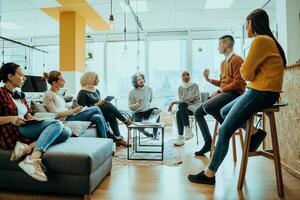 jung Designer geben etwas Neu Ideen Über Projekt zu seine Partner im Konferenz Zimmer. Geschäft Menschen diskutieren Über Neu Geschäft Projekt im Büro. foto