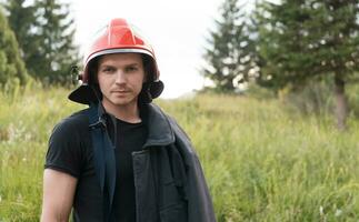 Feuerwehrmann mit Uniform und Helm Stand im Vorderseite von elektrisch Draht auf ein Dach oben foto