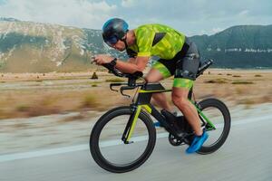 voll Länge Porträt von ein aktiv Triathlet im Sportbekleidung und mit ein schützend Helm Reiten ein Fahrrad. selektiv Fokus foto