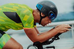 schließen oben Foto von ein aktiv Triathlet im Sportbekleidung und mit ein schützend Helm Reiten ein Fahrrad. selektiv Fokus