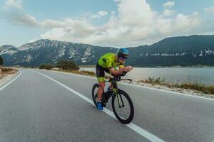 voll Länge Porträt von ein aktiv Triathlet im Sportbekleidung und mit ein schützend Helm Reiten ein Fahrrad. selektiv Fokus foto