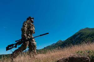 Heer Soldat halten ein Scharfschütze Gewehr mit Umfang und Gehen im das Wald. Krieg, Armee, Technologie und Menschen Konzept. foto