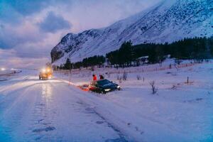 das Straßenrand Hilfe Bedienung ziehen das Auto aus von das Kanal. ein Vorfall auf ein gefroren skandinavisch Straße. foto