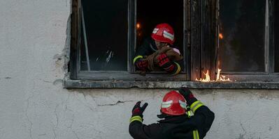 Feuerwehrmann Held Tragen Baby Mädchen aus von Verbrennung Gebäude Bereich von Feuer Vorfall. Rettung Menschen von gefährlich Platz foto