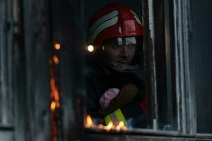 Feuerwehrmann Held Tragen Baby Mädchen aus von Verbrennung Gebäude Bereich von Feuer Vorfall. Rettung Menschen von gefährlich Platz foto