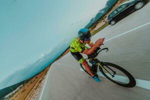 voll Länge Porträt von ein aktiv Triathlet im Sportbekleidung und mit ein schützend Helm Reiten ein Fahrrad. selektiv Fokus foto
