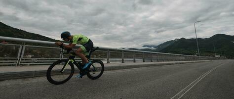 triathlonsportler, der beim morgendlichen training fahrrad fährt foto