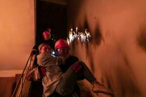 mutig Feuerwehrmann sinkt ab Treppe von ein Verbrennung Gebäude und hält Gerettet Mädchen im seine Waffen. öffnen Feuer und einer Feuerwehrmann im das Hintergrund. foto