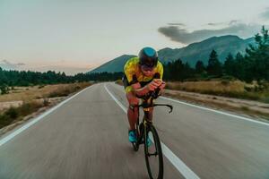 Nacht Antrieb. voll Länge Porträt von ein aktiv Triathlet im Sportbekleidung und mit ein schützend Helm Reiten ein Fahrrad im Nacht Zeit.. selektiv Fokus foto