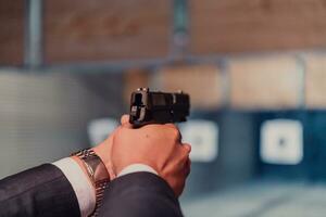 ein Mann Praktiken Methoden Ausübungen Schießen ein Pistole im ein Schießen Angebot während tragen schützend Kopfhörer foto
