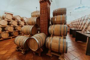 Wein oder Cognac Fässer im das Keller von das Weingut, hölzern Wein Fässer im Perspektive. Wein Gewölbe.vintage Eiche Fässer von Kunst Bier oder Brandy. foto