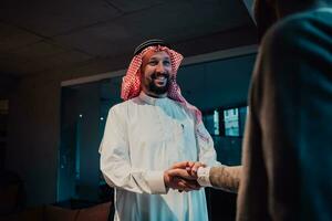 ein Alten arabisch Mann zittern Hände mit ein Geschäftsmann und Ende ein Geschäft Treffen mit erfolgreich Geschäft Angebote foto