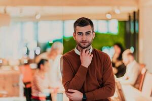 gutaussehender junger geschäftsmann, der selbstbewusst im büro vor seinem team steht foto