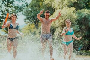 ein Gruppe von vielfältig jung Menschen haben Spaß zusammen wie Sie Lauf entlang das Fluss und abspielen Wasser Spiele foto