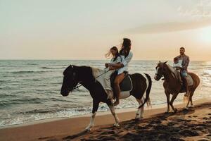 Die Familie verbringt Zeit mit ihren Kindern beim gemeinsamen Reiten an einem Sandstrand. selektiver Fokus foto