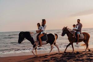 Die Familie verbringt Zeit mit ihren Kindern beim gemeinsamen Reiten an einem Sandstrand. selektiver Fokus foto