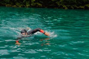 ein Triathlet im ein Fachmann Schwimmen passen Züge auf das Fluss während vorbereiten zum olympisch Schwimmen foto