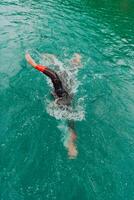 ein Triathlet im ein Fachmann Schwimmen passen Züge auf das Fluss während vorbereiten zum olympisch Schwimmen foto