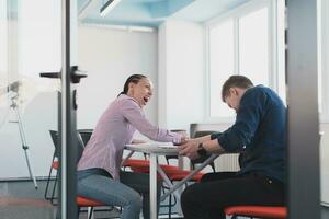 Geschäftsleute, Rivalität und Menschen Konzept - - Geschäftsfrau und Geschäftsmann Arm Ringen während korporativ Treffen im modern hell öffnen Raum Coworking Anfang Geschäft Büro. foto