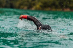 ein Triathlet im ein Fachmann Schwimmen passen Züge auf das Fluss während vorbereiten zum olympisch Schwimmen foto