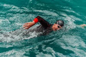 ein Triathlet im ein Fachmann Schwimmen passen Züge auf das Fluss während vorbereiten zum olympisch Schwimmen foto