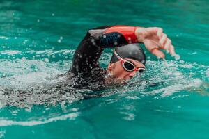 ein Triathlet im ein Fachmann Schwimmen passen Züge auf das Fluss während vorbereiten zum olympisch Schwimmen foto