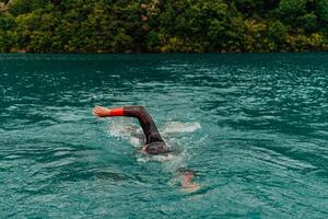 ein Triathlet im ein Fachmann Schwimmen passen Züge auf das Fluss während vorbereiten zum olympisch Schwimmen foto