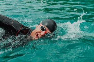 ein Triathlet im ein Fachmann Schwimmen passen Züge auf das Fluss während vorbereiten zum olympisch Schwimmen foto