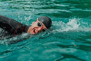 ein Triathlet im ein Fachmann Schwimmen passen Züge auf das Fluss während vorbereiten zum olympisch Schwimmen foto