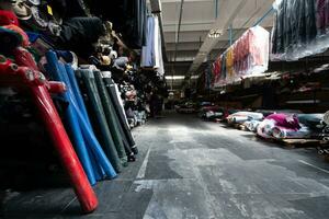 Innere von ein industriell Warenhaus mit Stoff Rollen Proben. klein Geschäft Textil- bunt Lagerhaus. foto