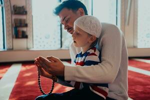 Muslim Gebet Vater und Sohn im Moschee gemeinsam beten foto