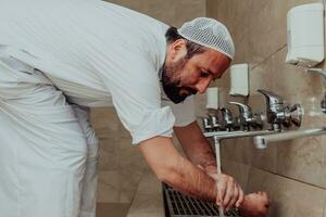 ein Muslim durchführen Waschung. Ritual religiös Reinigung von Muslime Vor durchführen Gebet. das Prozess von Reinigung das Körper Vor Gebet foto