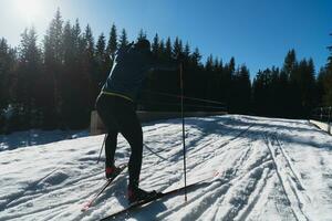 nordisch Skifahren oder Querfeldein Skifahren klassisch Technik geübt durch Mann im ein schön Panorama- Weg beim Morgen. foto