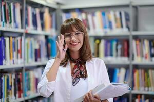 der Schüler benutzt ein Notizbuch und eine Schulbibliothek foto