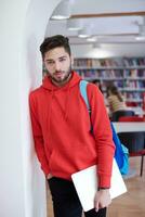 der Schüler benutzt einen Laptop und eine Schulbibliothek foto