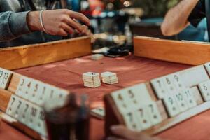 ein Gruppe von Männer trinken traditionell Türkisch Tee und abspielen ein Türkisch Spiel namens okey foto