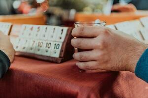 ein Gruppe von Männer trinken traditionell Türkisch Tee und abspielen ein Türkisch Spiel namens okey foto