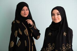 zwei schön Muslim Frau im modisch Kleid mit Hijab isoliert auf modern cyan Hintergrund Darstellen Konzept von modern Islam und Ramadan kareem foto