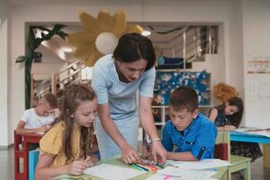 kreativ Kinder während ein Kunst Klasse im ein Kindertagesstätte Center oder elementar Schule Klassenzimmer Zeichnung mit weiblich Lehrer. foto