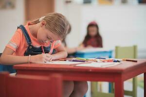 kreativ Kinder Sitzung im ein Vorschule Institution, zeichnen und haben Spaß während Sie erhalten ein Bildung foto