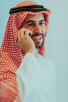 jung modern Muslim arabisch Geschäftsleute tragen traditionell Kleider während mit Smartphones beim heim. foto