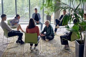 ein Mann Sitzung beim das Center von ein Kreis, leidenschaftlich Teilen seine Geschäft Ideen mit seine Kollegen, Förderung ein Atmosphäre von Zusammenarbeit und Innovation im ein dynamisch und einnehmend Arbeitsplatz. foto