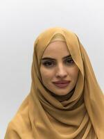 Porträt einer jungen muslimischen Frau, die Hijab auf isoliertem weißem Hintergrund trägt foto